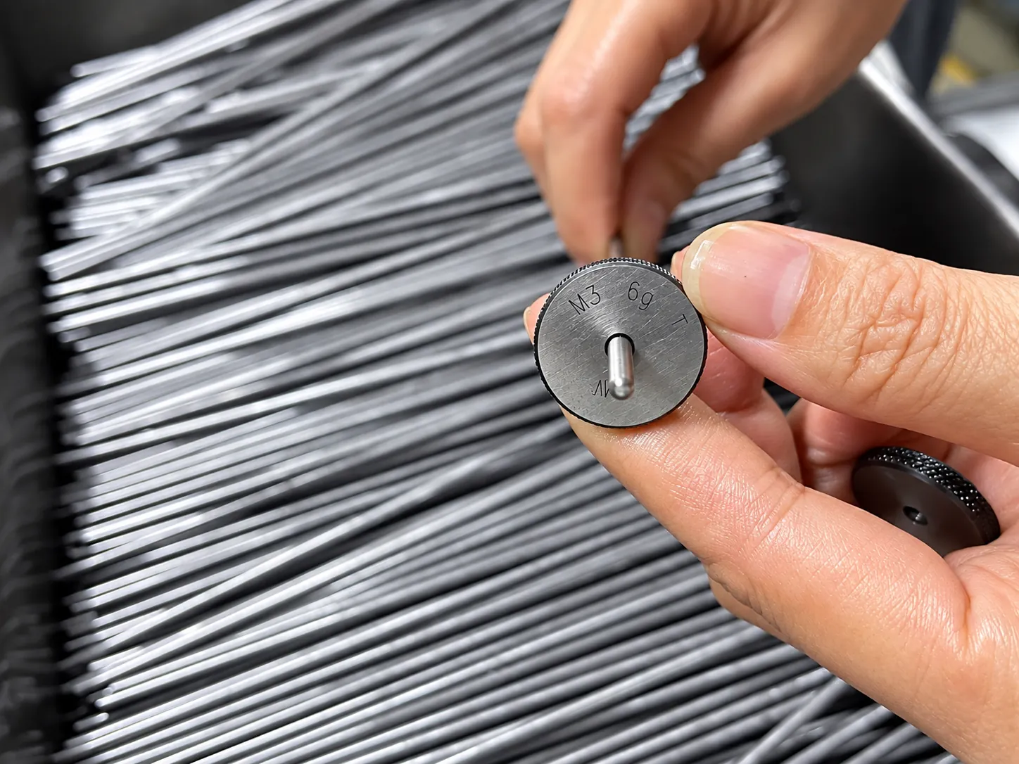 Engineer measuring custom fastener sample